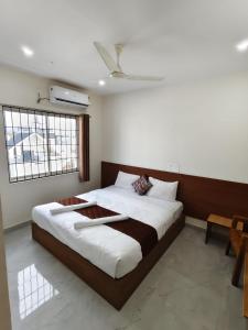 a bedroom with a large bed and a window at Hotel Relax inn in Chikmagalūr
