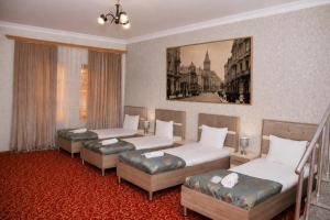 a room with two beds and two ottomans at Old Town Hotel in Baku