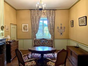 a room with a table and chairs and a window at Château de Lescure in Saint-Martin-sous-Vigouroux