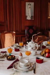 a table with a white table cloth with food and drinks at Château de Vitry-la-Ville in Vitry-la-Ville