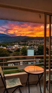 a table and chairs on a balcony with a sunset at Espectacular! Apartamento en cali cerca al coliseo del pueblo in Cali