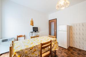 a small kitchen with a table and a refrigerator at All'antico Peso in Demonte