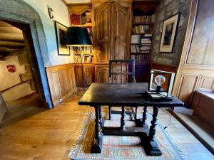 a room with a table and a chair in a library at Château de Lescure in Saint-Martin-sous-Vigouroux