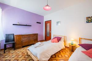 a bedroom with purple walls and a bed and a dresser at All'antico Peso in Demonte