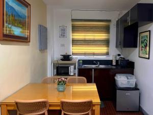 a small kitchen with a wooden table and chairs at A nature’s den in Tagaytay in Tagaytay
