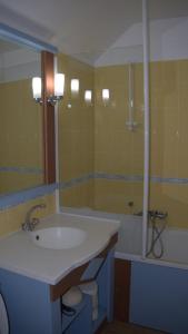 een badkamer met een wastafel, een bad en een spiegel bij Maison Vendée 2ch piscine wifi in Talmont