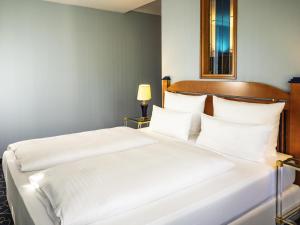 オーバーディングにあるAtomis Hotel Munich Airport by Mercureの白い枕が置かれたホテルの部屋にベッドが2つ
