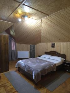 a bedroom with a large bed in a wooden ceiling at Cabana Magdalena in Câmpulung