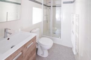 a white bathroom with a toilet and a shower at Auberge Le Cantou - Hôtel Roche in Orcival +25 photos