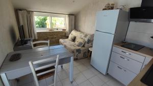 a small kitchen with a table and a refrigerator at Les Terrasses d'Antonin in Grambois