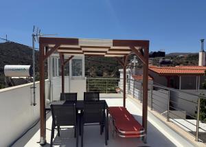 a patio with a table and chairs on a roof at Kalithea Palekastro in Palekastron