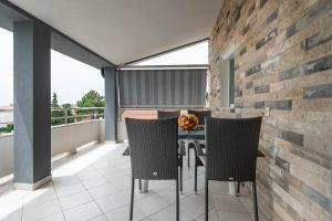 a balcony with chairs and a table on a balcony at Apartmani LUNA in Vir