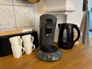 a coffee maker and coffee cups on a counter at L'échappée belle in Sixt-sur-Aff