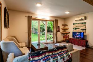 a living room with a couch and a chair at U Lesa Retreat - Nhà Bên Rừng in Sóc Sơn