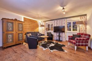 a living room with chairs and a tv and a table at Gästehaus Angela in Garmisch-Partenkirchen +30 photos