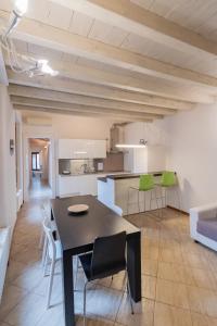a kitchen and dining room with a black table and chairs at Trilocale Rua Sovera 85 - F&L Aparment in Brescia +34 photos