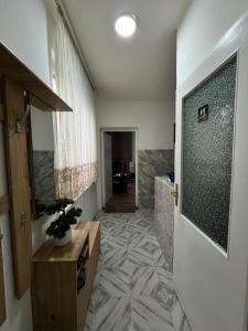 a bathroom with a walk in shower and a tiled floor at Apartman Pejovic N in Smederevo +6 photos