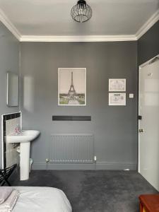 a bedroom with a bed and a sink and the eiffel tower at Victoria Inn in Alston