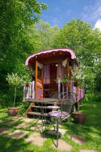 a house with a table and chairs in a yard at Roulotte du Rouard in Camiers