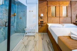 a bedroom with a bed and a glass shower at Letoh Apartment in Catania