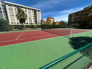 a tennis court in front of a large building at Chez Raka in Hyères
