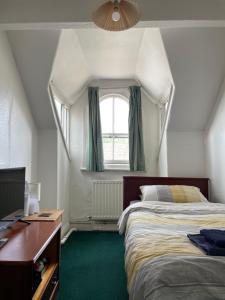 a bedroom with two beds and a desk and a window at Victoria Inn in Alston