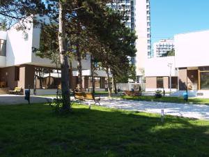 un parc avec des bancs, un arbre et des bâtiments dans l'établissement Complex Vile Neptun-Olimp, à Olimp