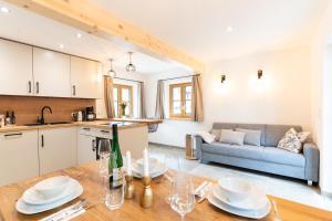 a kitchen and living room with a table and a couch at Chalet Kogelleiten in Ramsau