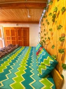 a bedroom with a bed with a green and yellow comforter at Canvas and Coffee in Kasol +16 photos