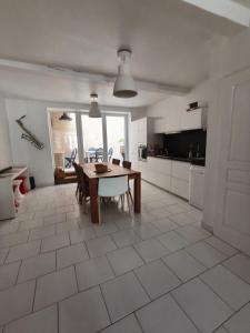 a kitchen and dining room with a table and chairs at Chez Marie, maison ArtY in Lauzun +18 photos
