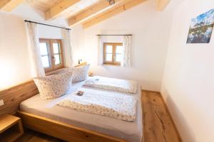 two beds in a room with two windows at Chalet Kogelleiten in Ramsau