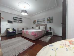 a bedroom with a bed and a table and a chair at GuestHouse Pombinha in Nazaré +24 photos