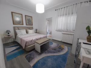 a bedroom with a bed and a table and a desk at GuestHouse Pombinha in Nazaré