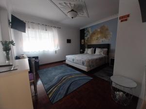 a bedroom with a bed and a window at GuestHouse Pombinha in Nazaré