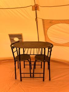 a wooden table and two chairs in a room at Prairie Junction Glamping Tent in Stettler