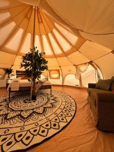 a large tent with a tree in the middle of a room at Prairie Junction Glamping Tent in Stettler +14 photos