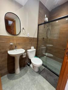 a bathroom with a toilet and a sink and a shower at HMG Morada & Chalet - Centro histórico in Petrópolis +26 photos