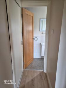 ein Flur mit einer Holztür in einem Badezimmer in der Unterkunft corrygarry in Kingscourt