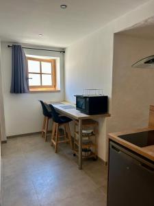 a kitchen with a table with chairs and a window at Studio le Replat in Aime-La Plagne