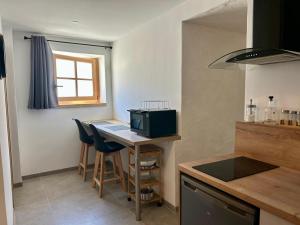 a kitchen with a table with chairs and a microwave at Studio le Replat in Aime-La Plagne