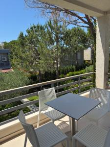 a white table and chairs on a balcony at Lalzi Vacation Apartment in Lalzit Bay