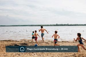 a group of children playing on the beach at Chalet Luméo Private SPA, Golf & carling Lake in Brownsburg