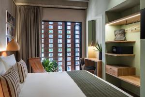 a hotel room with a bed and a large window at Obra Hotels in Medellín