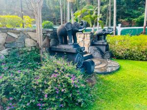 a statue of elephants on a fountain in a garden at The Kings Villa in Kandy +43 photos