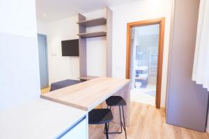 a kitchen with a counter and stools in a room at Essenza Residence in Cervia