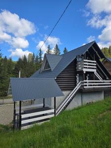 a house with a metal roof and a porch at Synevyr House 2 in Synevyrsʼka Polyana