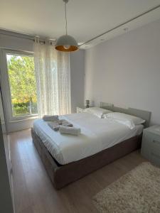 a bedroom with a large bed and a large window at Lalzi Vacation Apartment in Lalzit Bay