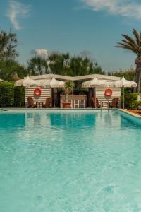 a large swimming pool with chairs and umbrellas at Epi Baie de Pampelonne in Saint-Tropez