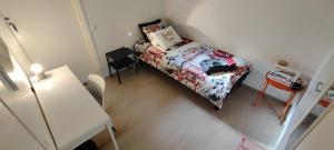 a small bedroom with a bed and a table at City & Forest Relax Room with Private Sauna & Garden in Espoo