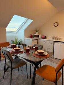a room with a table with chairs and a kitchen at Homestay Wild Atlantic View Binghamstown in Belmullet
